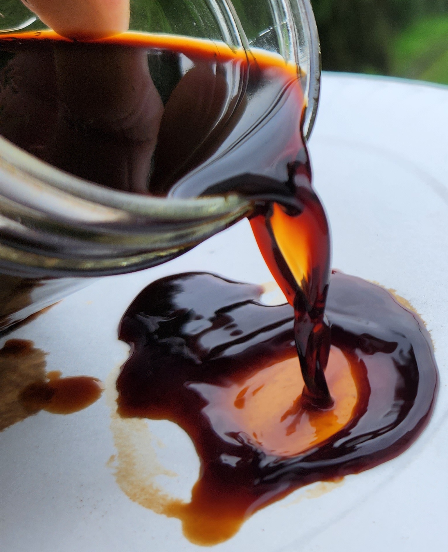 Bio-oil being poured from a jar, produced by iNBIO via fast pyrolysis